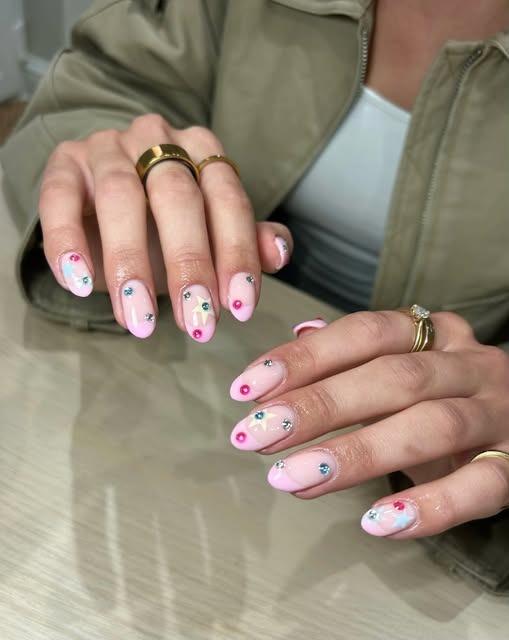 Soft pink nails with delicate multicoloured floral and gem detail